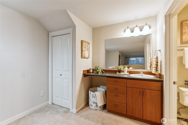 bathroom featuring vanity, baseboards, and carpet floors