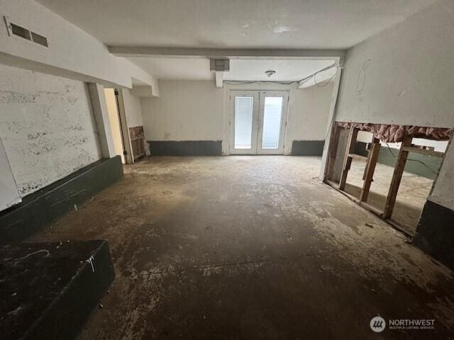 interior space with french doors, visible vents, and unfinished concrete floors