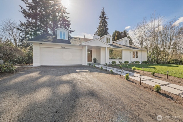 view of front of house with driveway, a front lawn, and an attached garage