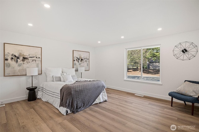 bedroom with baseboards, wood finished floors, and recessed lighting