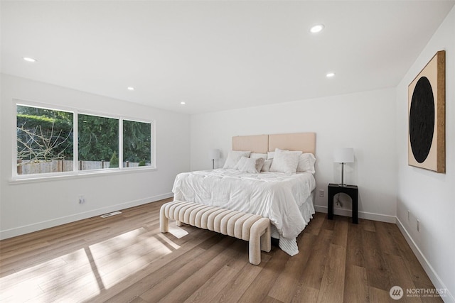 bedroom with recessed lighting, wood finished floors, visible vents, and baseboards