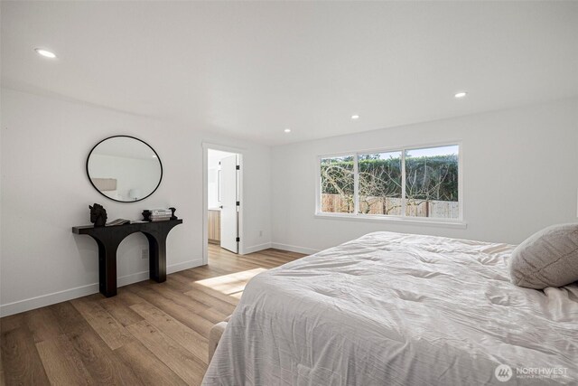 bedroom featuring baseboards, wood finished floors, and recessed lighting