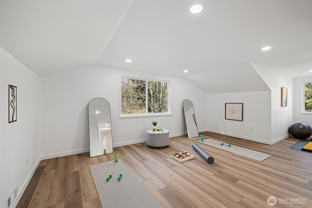 workout room featuring lofted ceiling, wood finished floors, visible vents, and recessed lighting