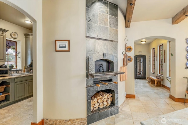 1939 49th St, Port Townsend, WA 98368 - hallway with a sink, beamed ceiling, arched walkways, light tile patterned floors, and baseboards