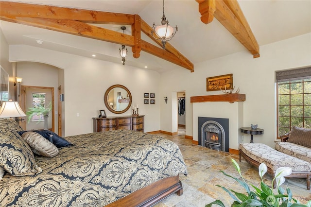 1939 49th St, Port Townsend, WA 98368 - bedroom with stone tile flooring, a lit fireplace, baseboards, arched walkways, and a spacious closet