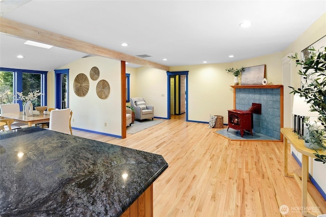 living room featuring light wood-type flooring, visible vents, beam ceiling, and recessed lighting