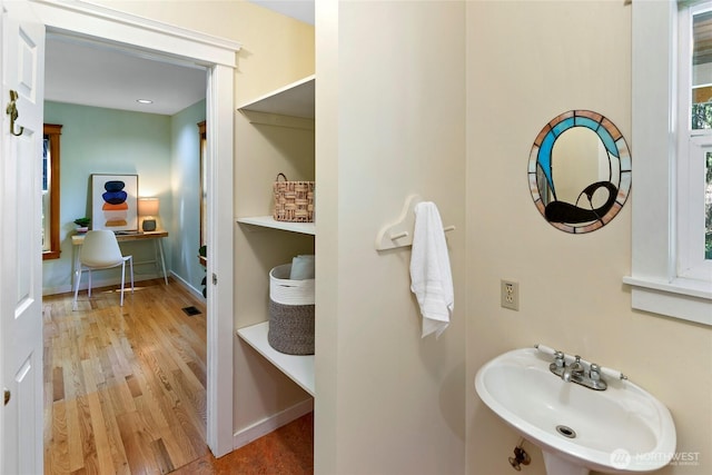 bathroom with baseboards, a sink, and wood finished floors