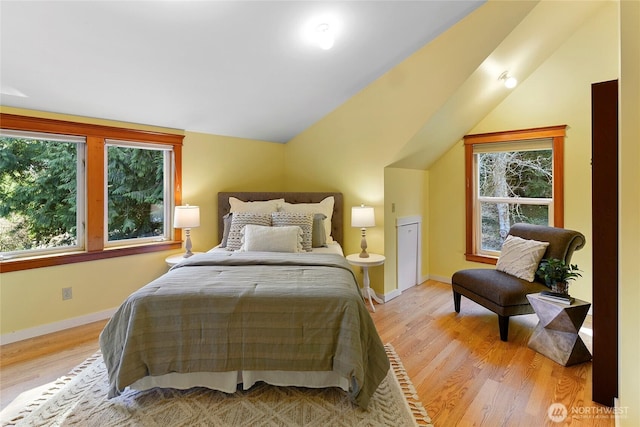 bedroom with baseboards, vaulted ceiling, and wood finished floors