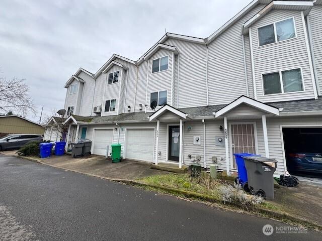 townhome / multi-family property featuring driveway and an attached garage