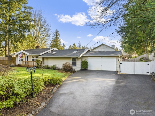 single story home with a front lawn, fence, aphalt driveway, an attached garage, and a gate