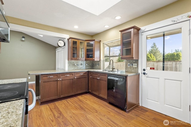 kitchen with backsplash, dishwasher, stainless steel range with electric stovetop, light wood-style floors, and a sink