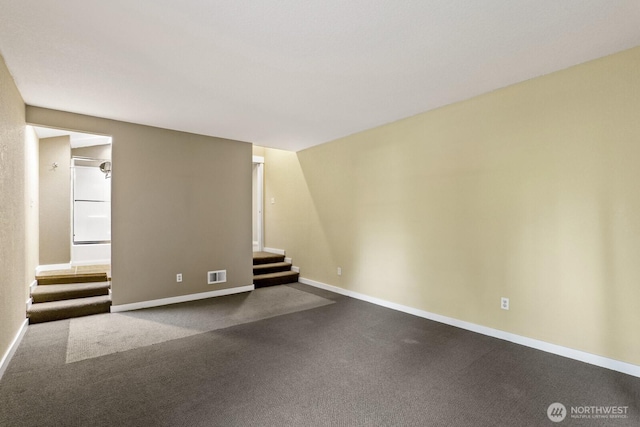 interior space featuring stairs, baseboards, visible vents, and dark carpet