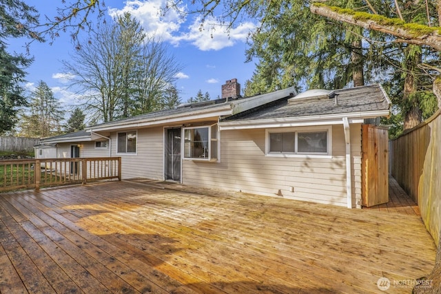 view of front of property with a chimney, a wooden deck, and fence