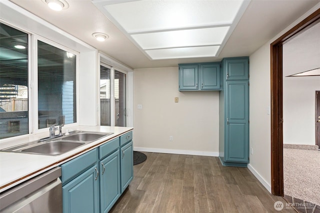 kitchen featuring a sink, blue cabinets, dark wood-type flooring, and dishwasher