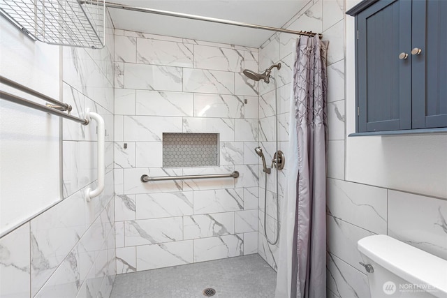 full bath featuring tile walls, a shower stall, and toilet