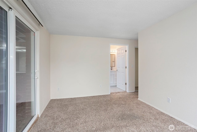 unfurnished room featuring light carpet and a textured ceiling