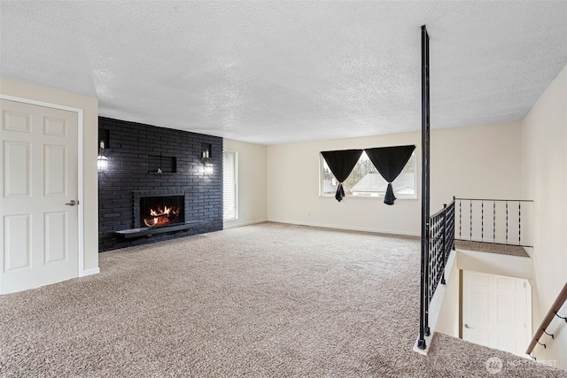 unfurnished living room featuring carpet flooring, a fireplace, a textured ceiling, and baseboards