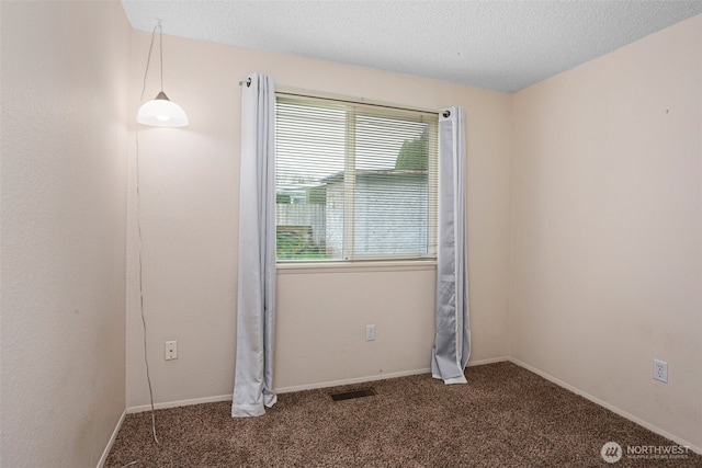 empty room featuring a textured ceiling, carpet flooring, visible vents, and baseboards