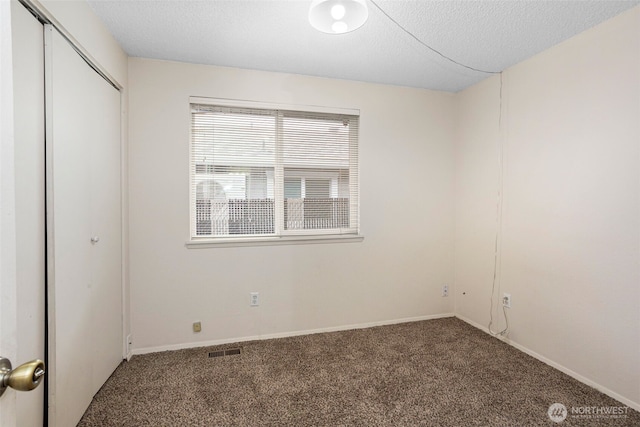 unfurnished bedroom featuring carpet floors, a closet, visible vents, and a textured ceiling