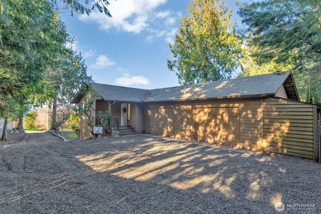 view of front of property featuring roof with shingles, driveway, and an attached garage