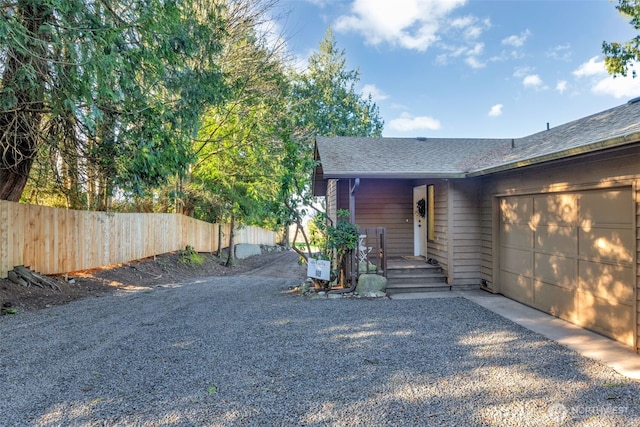 view of front of property with a garage, driveway, and fence