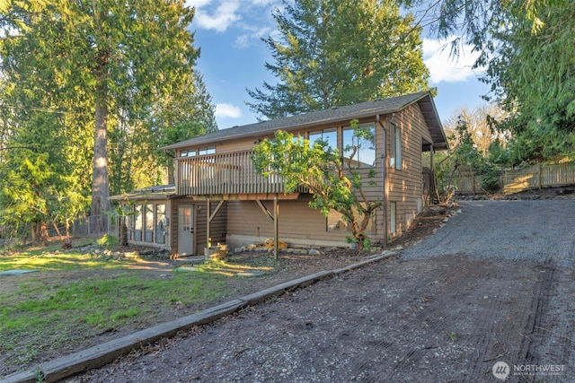 view of front of house with fence and a deck