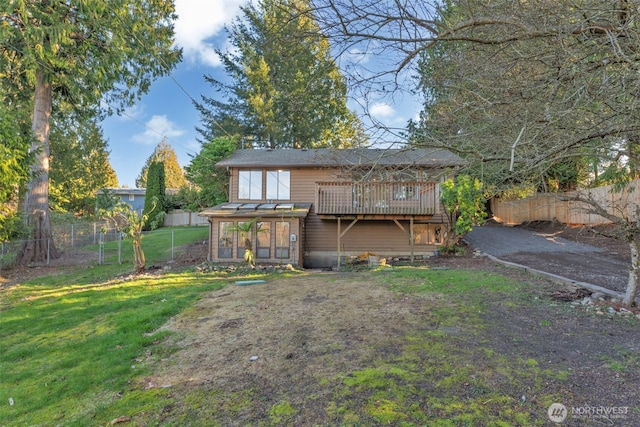 back of house with a yard and a fenced backyard