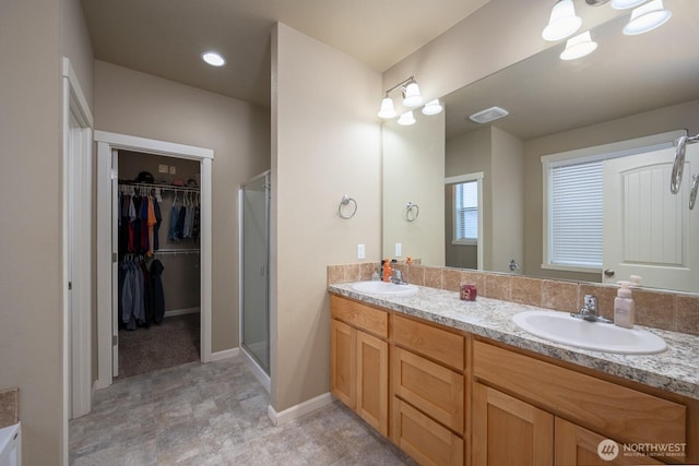 bathroom featuring double vanity, a sink, visible vents, and a shower stall