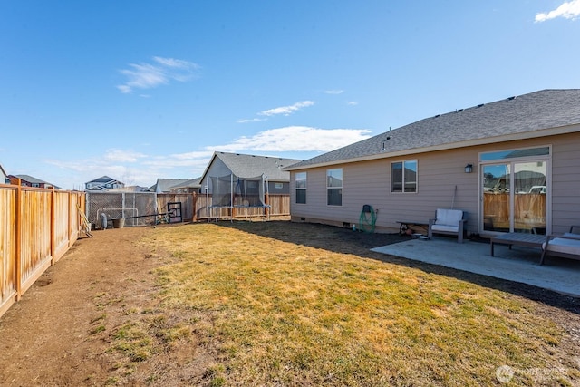 rear view of house featuring a patio, a trampoline, a fenced backyard, and a lawn