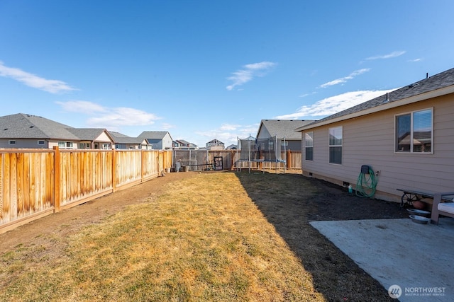 view of yard with a trampoline, a residential view, and a fenced backyard