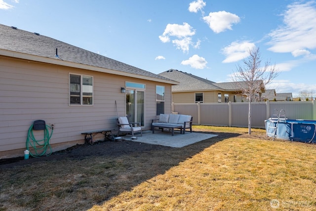 rear view of house with a patio, a yard, fence, and a fenced in pool