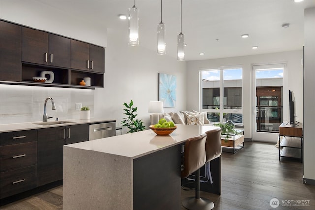 kitchen featuring dark wood-style floors, dark brown cabinetry, a sink, and dishwasher