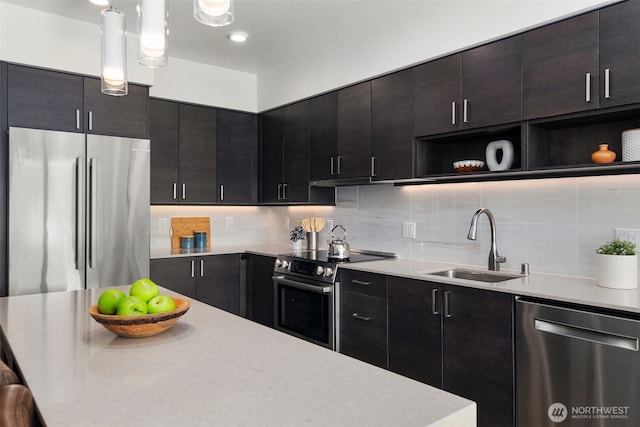 kitchen featuring appliances with stainless steel finishes, light countertops, a sink, and open shelves