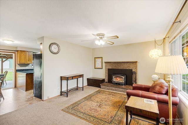 living room featuring baseboards, light colored carpet, and a ceiling fan