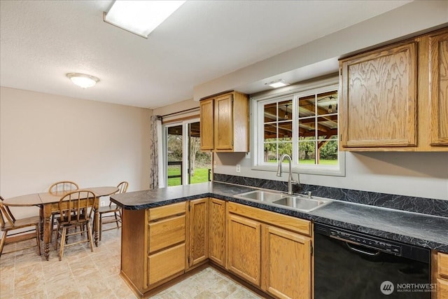 kitchen featuring a peninsula, a sink, black dishwasher, a textured ceiling, and dark countertops