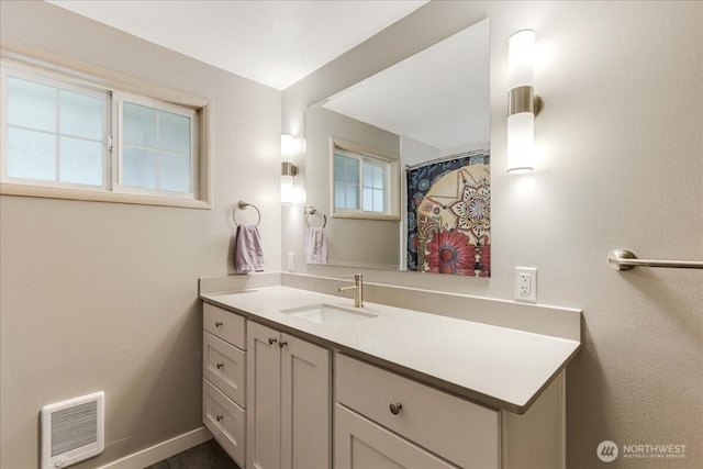 full bath featuring baseboards and vanity