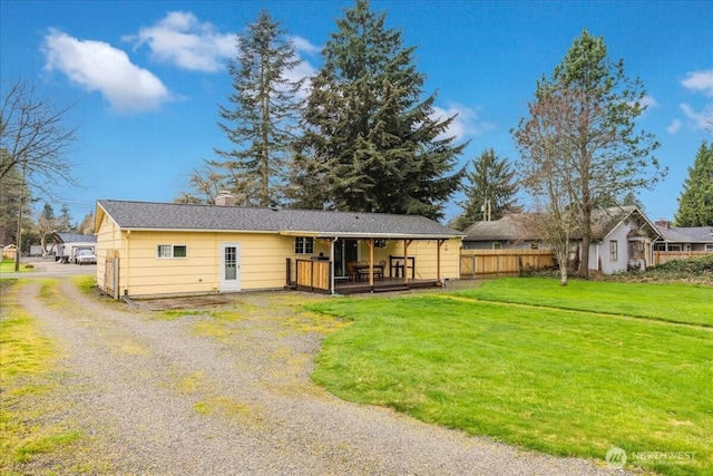 view of front of home with driveway, a front yard, and fence