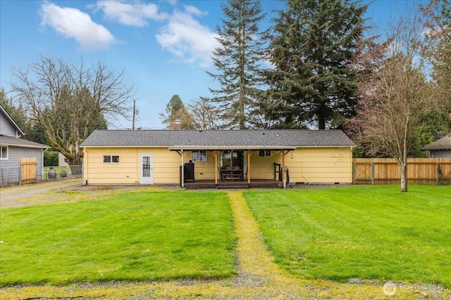 rear view of house featuring a yard, fence, and a chimney