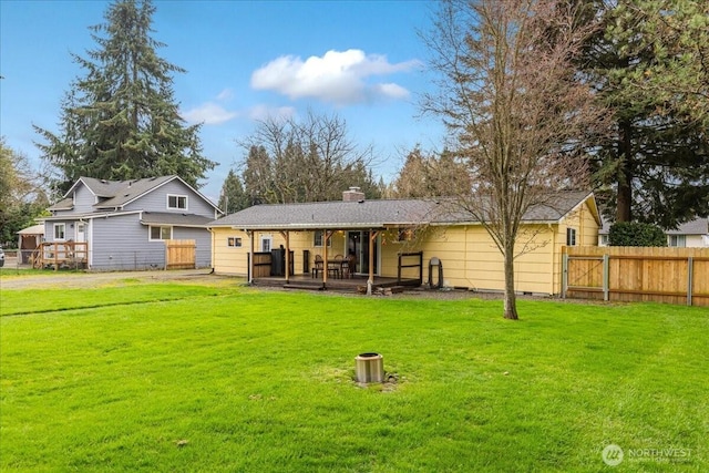 rear view of property with crawl space, a lawn, a chimney, and fence