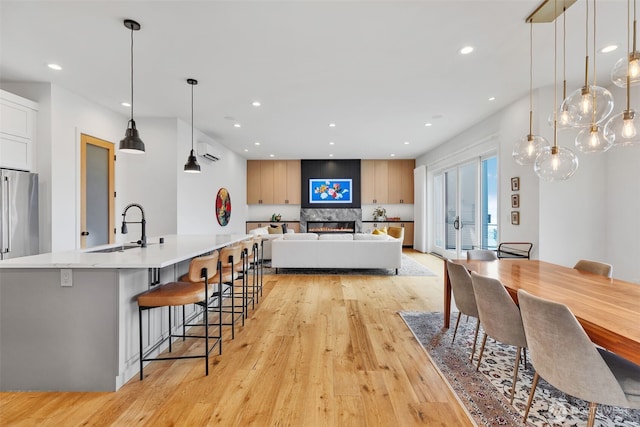 dining room with a wall unit AC, recessed lighting, and light wood finished floors