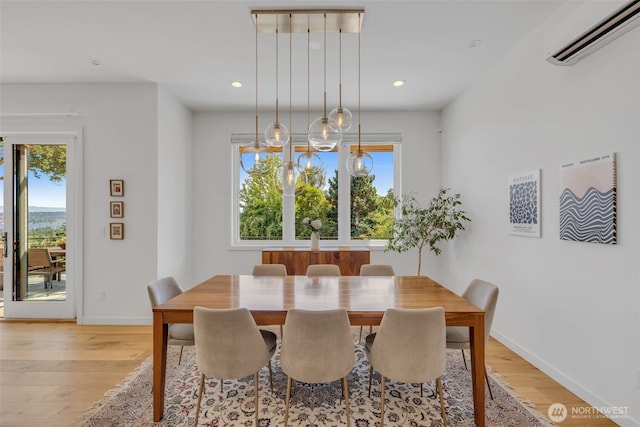 dining area featuring recessed lighting, baseboards, light wood-type flooring, and a wall unit AC