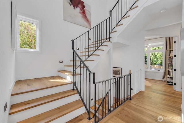 staircase with baseboards and wood finished floors