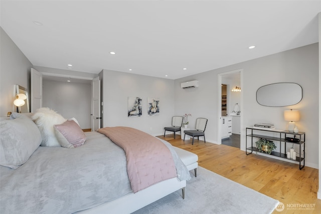 bedroom with recessed lighting, light wood-style flooring, baseboards, and a wall unit AC