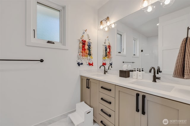 bathroom with double vanity, a shower, and a sink