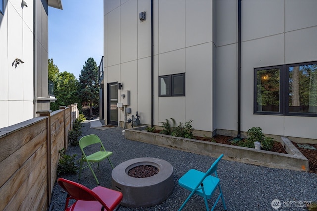 view of patio featuring fence and a fire pit