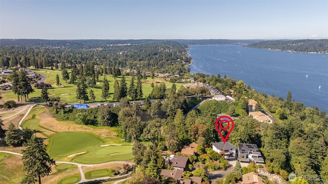 birds eye view of property with a wooded view, golf course view, and a water view