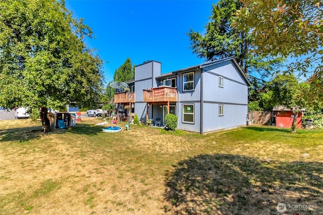 back of house with a wooden deck and a yard