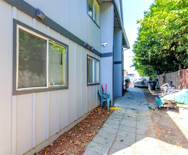 view of side of home featuring fence and board and batten siding