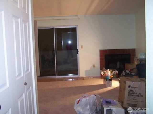 carpeted living room featuring a brick fireplace