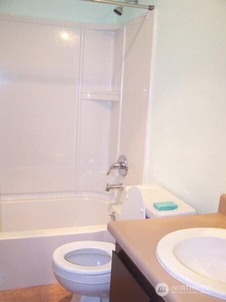 bathroom featuring toilet, vanity, and shower / bathtub combination